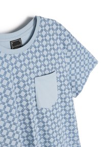 Jasnoniebieska koszulka z krótkim rękawem z geometrycznym wzorem w kolorze granatowym. Posiada jednolitą kieszeń po lewej stronie klatki piersiowej. Gładka bawełniana tekstura.