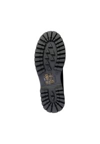 Suela de zapato de goma negra con profundos surcos, que presenta patrones triangulares y una pequeña etiqueta impresa con instrucciones de cuidado cerca del área del talón.