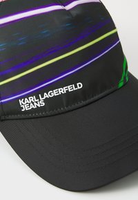 Čierna čiapka s farebným pásikovým vzorom v purpurovej, zelenej a žltej farbe. Na prednej strane je text "KARL LAGERFELD JEANS" v bielej farbe.