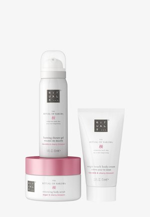 Tre hudpleieprodukter i hvit og rosa emballasje: skummende dusjgelé, fornyende kroppsskrubb og magisk kroppskrem, alle merket "Ritual of Sakura."