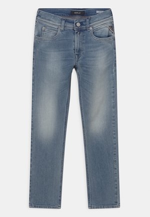 Niebieskie wyblakłe dżinsy o dopasowanym kroju, z kieszeniami z przodu i na monety, zapinane na guziki, z szelkami na pasek, ułożone płasko na białym tle.