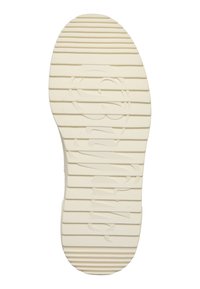 Semelle d'une chaussure beige clair avec des rainures horizontales et un logo de marque en relief qui s'étire sur toute la longueur au centre.