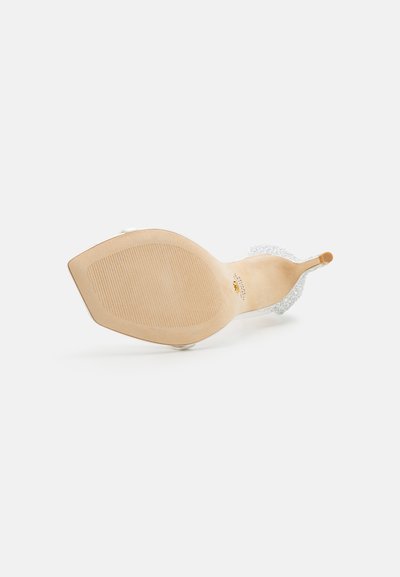 Sandale à talon haut avec une bride transparente, un dessus transparent et une semelle en simili cuir texturée de couleur beige. Dispose d'un talon fin et d'un design ouvert à l'avant.