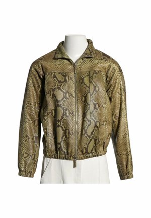 Chaqueta marrón clara con cremallera, patrón de piel de serpiente y puños y dobladillo elásticos, exhibida sobre un torso de maniquí blanco.