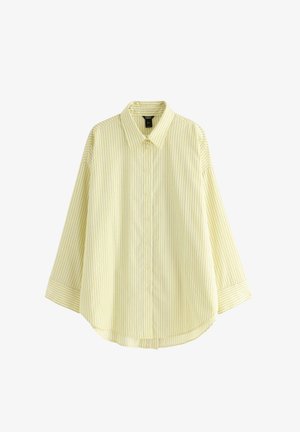 Camicia a righe gialle con scollo a collo, chiusura frontale con bottoni e maniche a tre quarti. Presenta sottili righe verticali blu su un tessuto morbido.