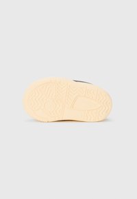 Hvit gummisåle til sneakers med teksturert mønster, med en jevn beige mellomsåle og subtil merkevarelogo.