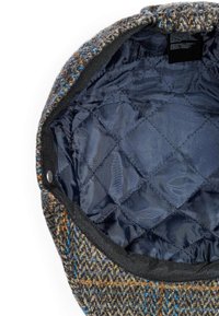 Wool blend cap with a textured, multicolored exterior featuring shades of brown, blue, and orange. Interior lined with dark, quilted material.