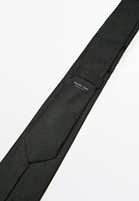 Cravate noire tissée avec une finition texturée, comportant une étiquette de logo portant "Massimo Dutti" et une doublure lisse pour plus de confort.