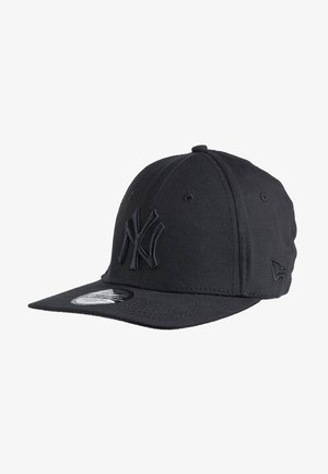 Czarna czapka bejsbolowa New York Yankees z płaskim daszkiem i wypukłym, haftowanym logo z przodu, widziana z przedniego lewego kąta.