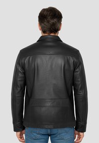 Schwarze Lederjacke mit glatter Textur, Reverskragen und maßgeschneiderter Passform. Verfügt über sichtbare Nähte und ein Rückenteil-Design.