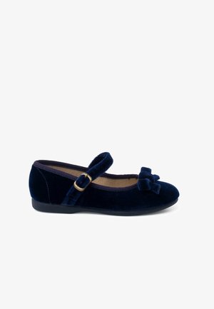 Zapato Mary Jane de terciopelo azul marino con punta redonda, correa ajustable con hebilla dorada y adorno de lazo en la parte delantera. Diseño de suela plana.