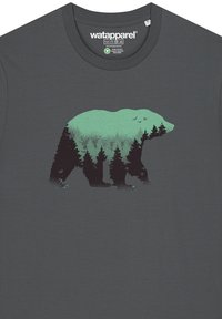 T-shirt en coton gris avec une silhouette verte d'un ours fusionnant avec une scène forestière. Col rond et manches courtes.