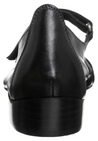 Scarpa in pelle nera con un design elegante, tacco basso, punta arrotondata e cinghietta alla caviglia, caratterizzata da una texture liscia e cuciture sottili.