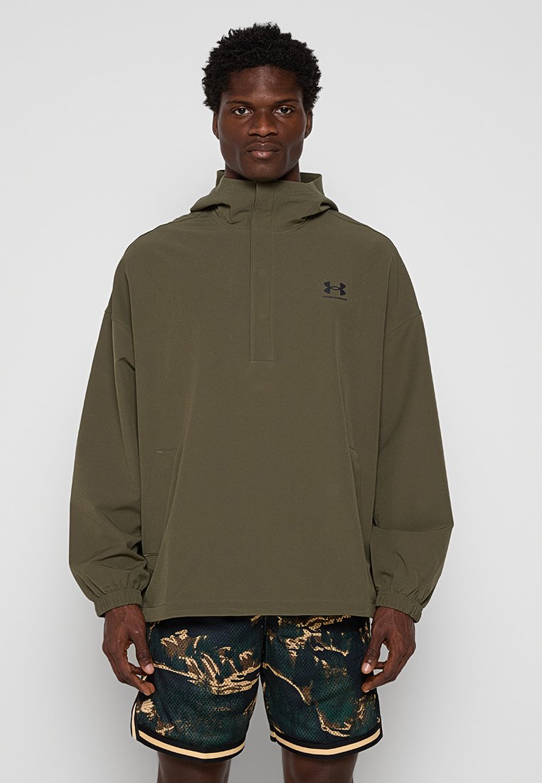Cazadora tipo windbreaker en color caqui, con capucha y cierre de cuarto de cremallera en la parte frontal, que cuenta con un bolsillo tipo canguro y un logo bordado en el pecho.