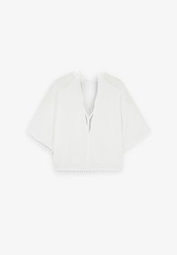 Top court blanc avec un col en V, des manches courtes et un bord en dentelle. Fabriqué à partir d'un tissu léger, avec des accents de maille transparente aux épaules.