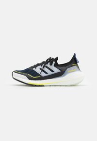 Czarne buty do biegania z oddychającą siateczką wierzchnią, białą podeszwą środkową, neonowo-żółtymi akcentami i niebieską pętelką na pięcie. Posiadają branding w postaci trzech pasków.