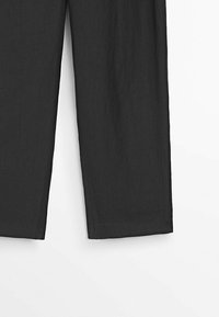 Pantalons en lin noirs au design à jambe droite, présentant une texture douce et une finition de bord propre. Pas de poches visibles ni d'ornements.