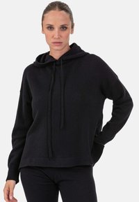 Sweat-shirt à capuche noir à coupe décontractée, avec poignets et ourlet côtelés. Confectionné dans une matière douce ; doté de cordons ajustables à la capuche.