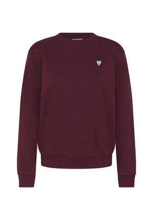 Tummanpunainen pyöreäkauluksinen collegepaita, jossa pitkät hihat ja resorikäänteet, ja pieni vaaleansininen sydänmerkki vasemmassa ylärinnassa.