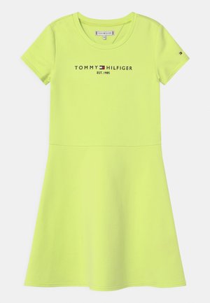 Vestido corto de manga corta en verde neón con cuello redondo, logo de Tommy Hilfiger y bandera en el pecho, y leve vuelo desde la cintura hasta el dobladillo.