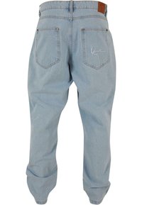 Pantaloni in denim azzurro chiaro con vestibilità rilassata, dotati di cinque tasche e un logo ricamato sulla tasca posteriore destra.