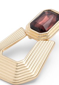 Geometrische gouden oorbel met een diep rode rechthoekige edelsteen, ribbelstructuur op het metaal en een holle centrumontwerp.