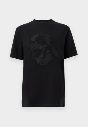 T-shirt noir à manches courtes avec un graphisme en relief d'un homme portant des lunettes de soleil et un col montant, centré sur le devant.