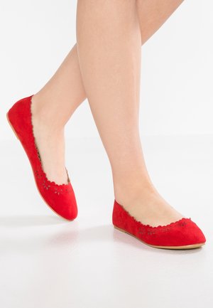 Czerwone zamszowe baletki z falbaniastymi krawędziami i małymi kwiatowymi wycięciami z przodu. Płaska podeszwa i smukły kształt.