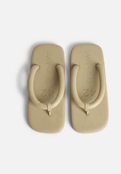 Beige flip-flopit, jotka on valmistettu pehmeästä materiaalista, jossa on paksu, pyöreä hihna ja teksturoitu pohja. Brändin nimi "Camperlab" on prässätty pohjaan.