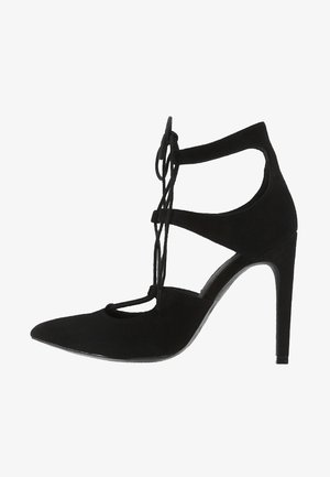 Zwarte pumps van zacht suède, met een open teen, crisscross bandontwerp en een spitse neus met een glanzende zool.