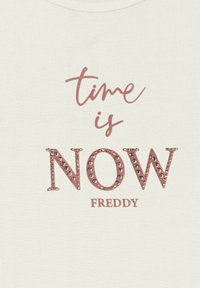 Tessuto color crema con il testo "il tempo è ORA" in rosa con strass, e "FREDDY" sotto in un font rosa più piccolo.