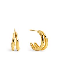 Orecchini a cerchio color oro con un design ondulato e una finitura lucida. La forma è ampia e arrotondata, con accenti testurizzati.