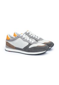Graue und weiße Sneakers aus Leder und Wildleder, mit orangenen Akzenten, strukturierten Details und einem klassischen Schnürdesign.