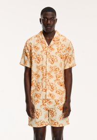 Korte mouw overhemd met knoopsluiting en bijpassende short, beige met een oranje bloemenpatroon, lichte stof, casual ontwerp, ontspannen pasvorm.