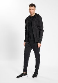 Hummel HMLMT INTERVAL TAPERED - Pantalones deportivos - black