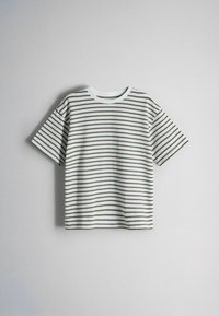 Camiseta blanca de manga corta con finas rayas horizontales marrones, presentada sobre un fondo liso gris claro.