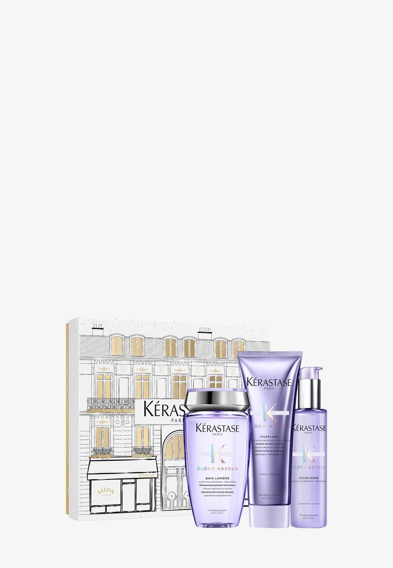 Zestaw prezentowy Kérastase Blond Absolu zawierający trzy fioletowe butelki: szampon, odżywkę i serum. Pudełko ozdobione jest wzorem paryskiego budynku.