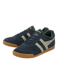 Sneakers in suede blu navy con strisce beige e suola in gomma. Presentano un design con lacci e un collo imbottito per il massimo comfort.