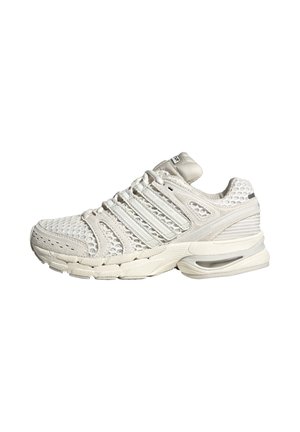 Baskets blanches de sport avec dessus en mesh, multiples œillets pour lacets, semelle amortie avec unité d'air visible et détail texturé au talon.