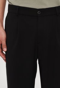 Sorte bukser med en glat tekstur, der har en lige pasform, en enkelt knaplukning og sidelommer. Enkel design med minimale syninger.