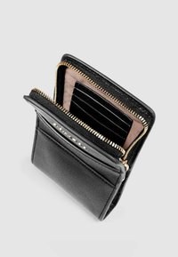 Cartera de cuero negro con cremallera dorada, ranuras interiores para tarjetas y textura a rayas. Presenta un acabado suave y un brillo sutil. Diseño plegado.