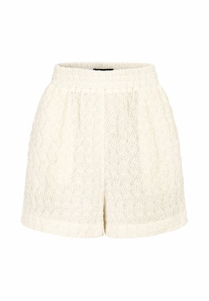 Białe szorty z teksturowanej tkaniny z elastycznym paskiem i delikatnym falistym wzorem, wyeksponowane na gładkim białym tle.