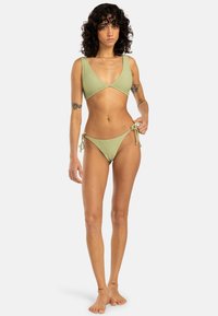 Light green bikini set featuring a triangular top with side ties and low-rise bottoms. Made from ribbed fabric with a smooth texture.