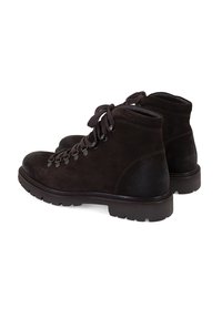Bruine suède enkelboots met ronde neuzen, vetersluiting aan de voorkant en textuurelementen. Rubber zolen zijn voorzien van gripgroeven.