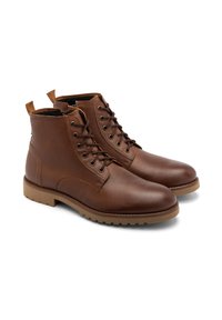 Brązowe skórzane botki za kostkę o teksturowanym wykończeniu, z wiązaniem, podwójnymi pętlami do zakładania oraz gumową podeszwą z bieżnikiem zapewniającym przyczepność.