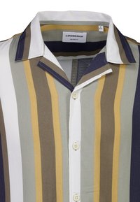 Avslappet skjorte med vertikale striper i olivengrønn, beige, sennep og marineblå. Har klassisk krage og knappelukking foran.