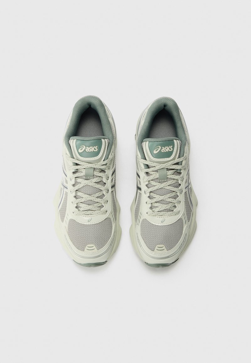 Baskets de sport vert clair en matériaux synthétiques et en maille, dotées de lacets, d'un col rembourré et du logo Asics sur la languette.