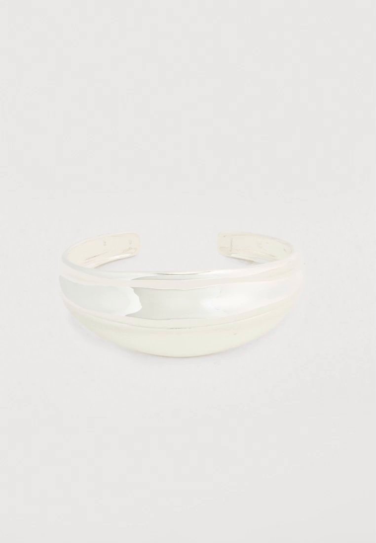 Un bracelet manchette ouvert blanc translucide, avec une bande lisse et arrondie, présenté sur un fond clair uni.