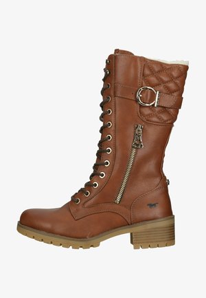 Bottes en cuir marron montantes avec un laçage sur le devant, fermeture éclair sur le côté, motif matelassé en haut et un talon bloc. Accents en métal doré inclus.