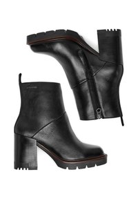 Botas de cuero negro hasta el tobillo con tacón cuadrado, cierre lateral de cremallera y suela texturizada, con un discreto logotipo en la parte superior.